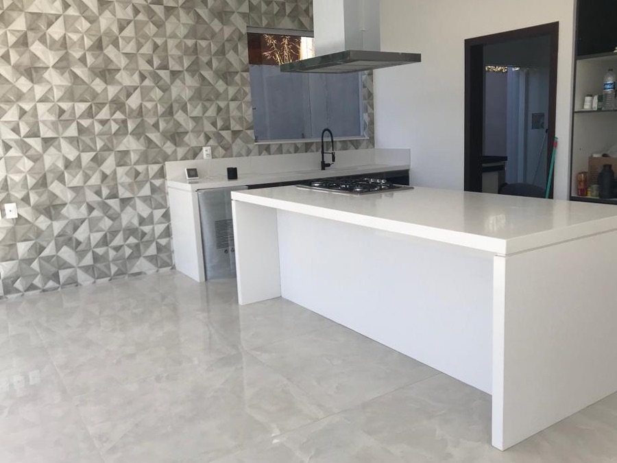 Cozinha com ilha central clara e cooktop embutido